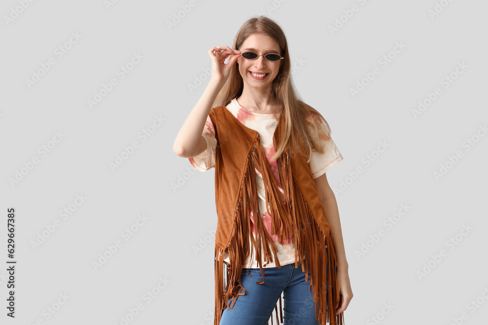 Young woman in tie-dye t-shirt on light background