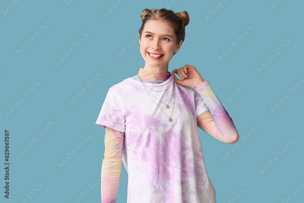 Young woman in tie-dye t-shirt on blue background