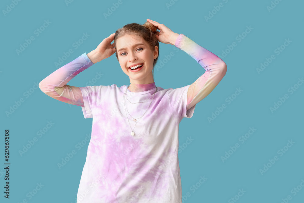 Young woman in tie-dye t-shirt on blue background