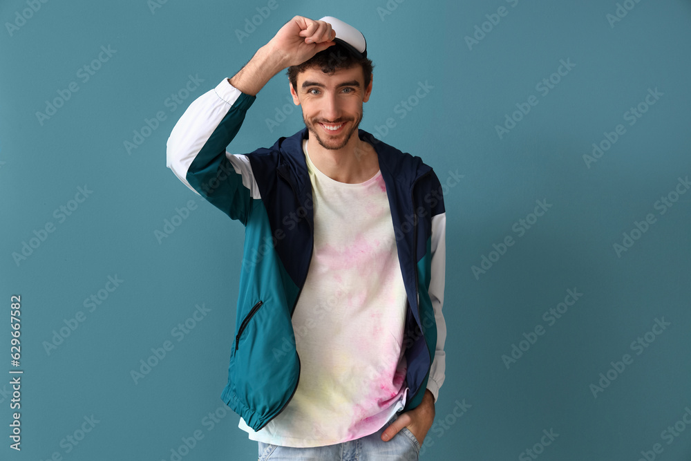 Stylish young man in tie-dye t-shirt on blue background