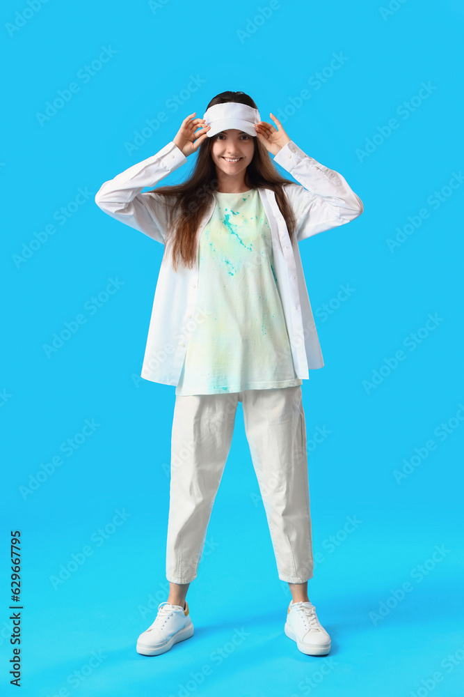 Stylish young woman in tie-dye t-shirt on light blue background