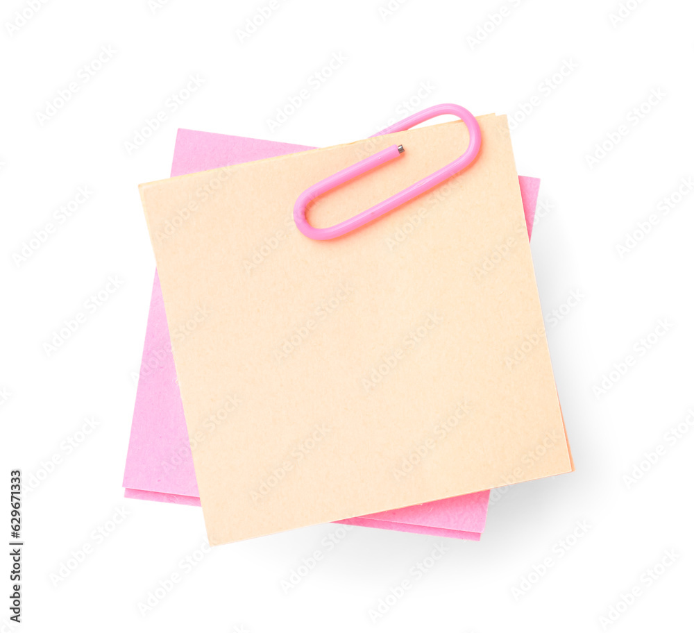 Pink and beige sticky notes with paper clip on white background