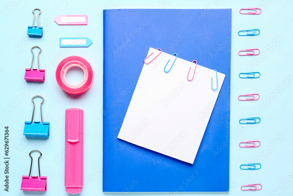 Composition with sticky note and stationery on blue background