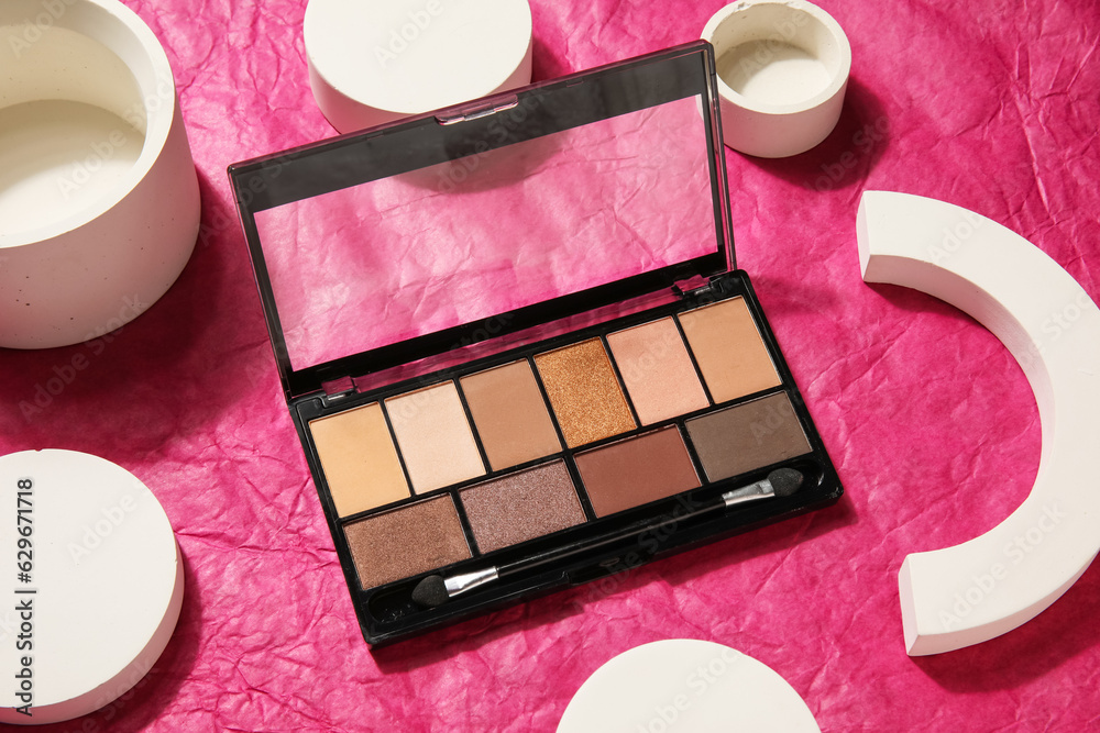 Palette of eyeshadows with podiums on crumpled paper background, closeup