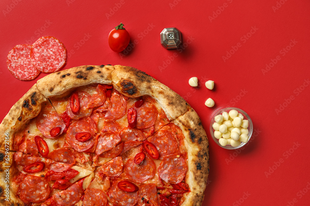 Delicious pepperoni pizza and ingredients on red background