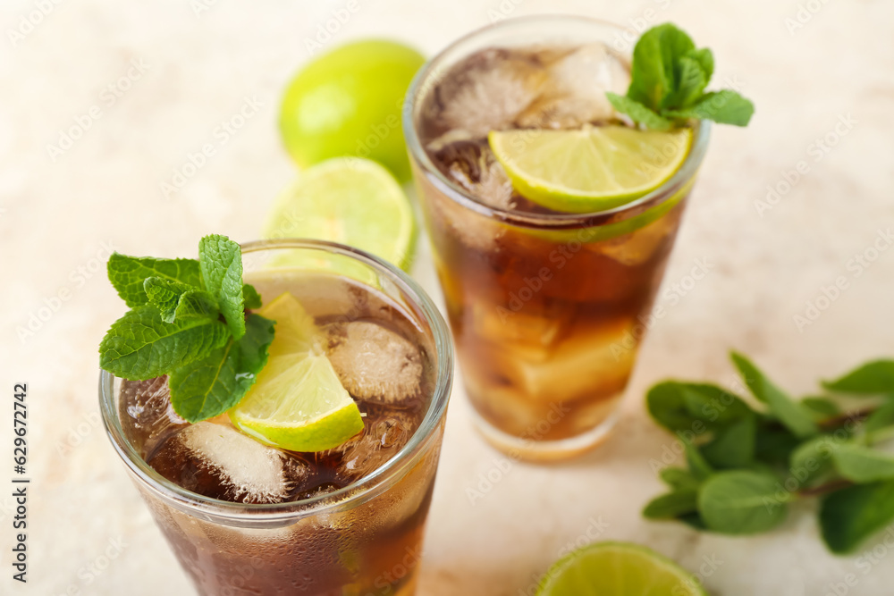 Glasses of tasty Cuba Libre cocktail on light background, closeup