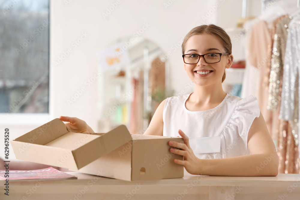 Female seller with shoe box in boutique