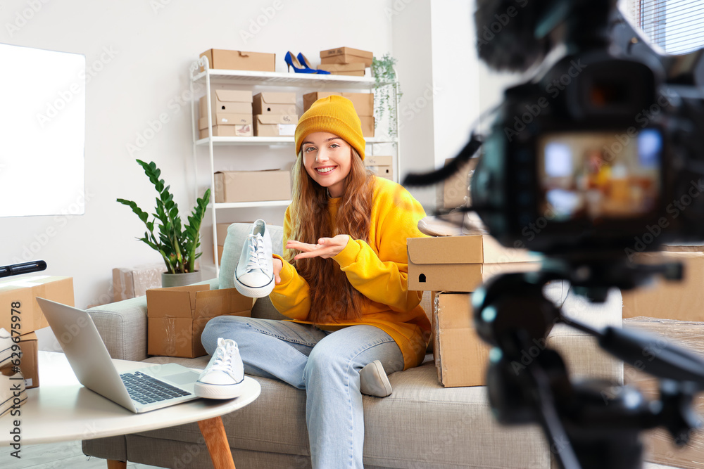 Female seller with shoes recording video at home