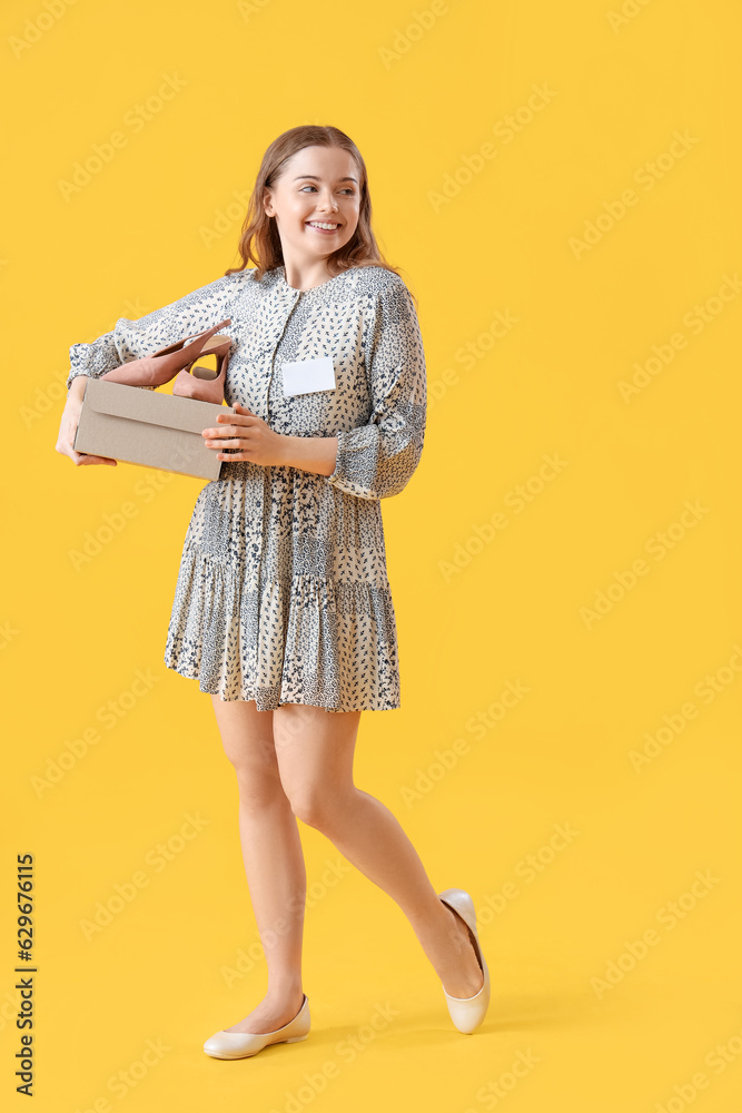 Female seller with shoes on yellow background