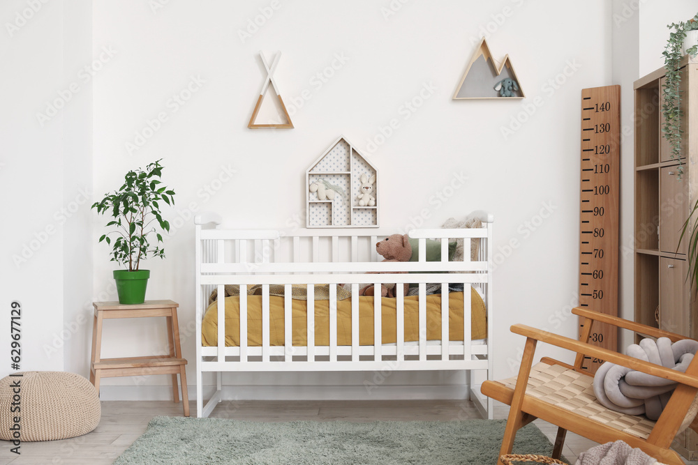 Interior of childrens bedroom with crib, shelves and toys