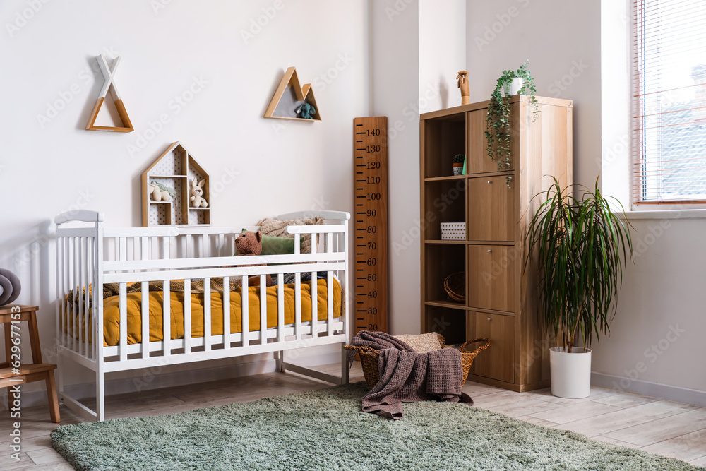 Interior of childrens bedroom with crib, shelves and toys