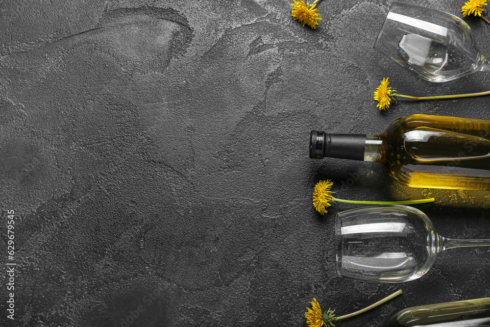 Bottle and glasses of dandelion wine on black background