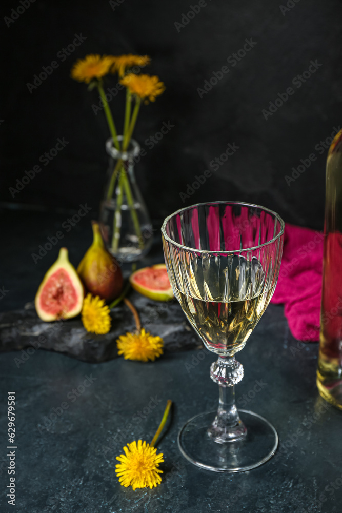 Glass of dandelion wine on dark table