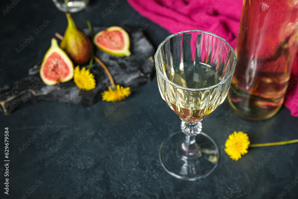 Glass of dandelion wine on dark table