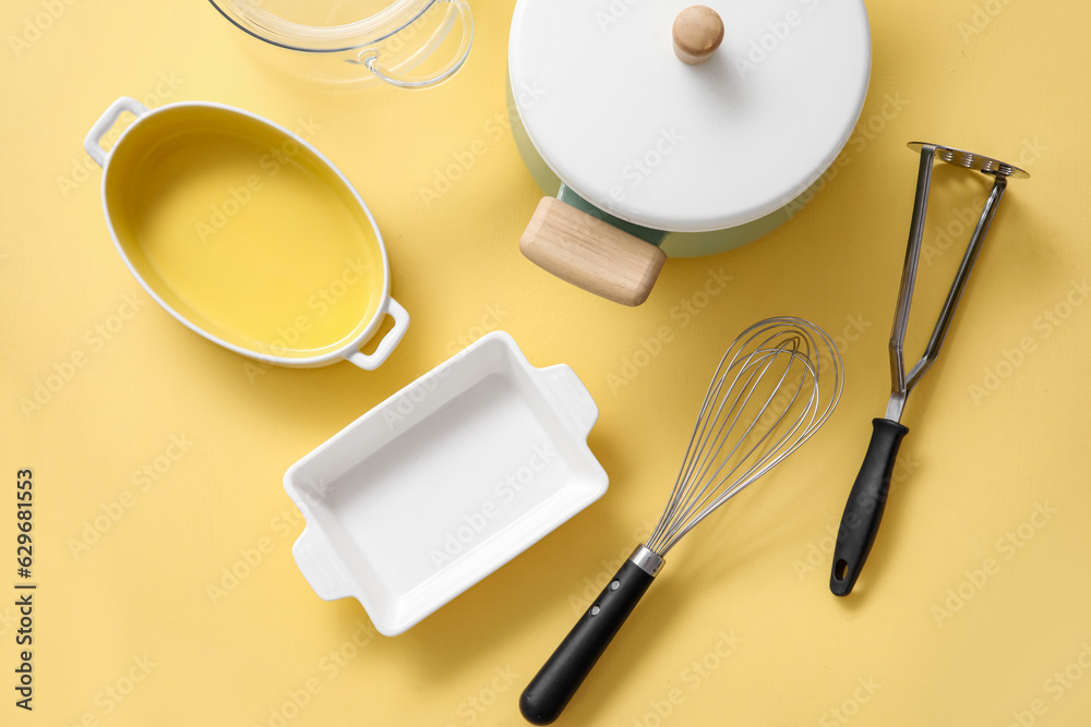 Set of different kitchen utensils on beige background