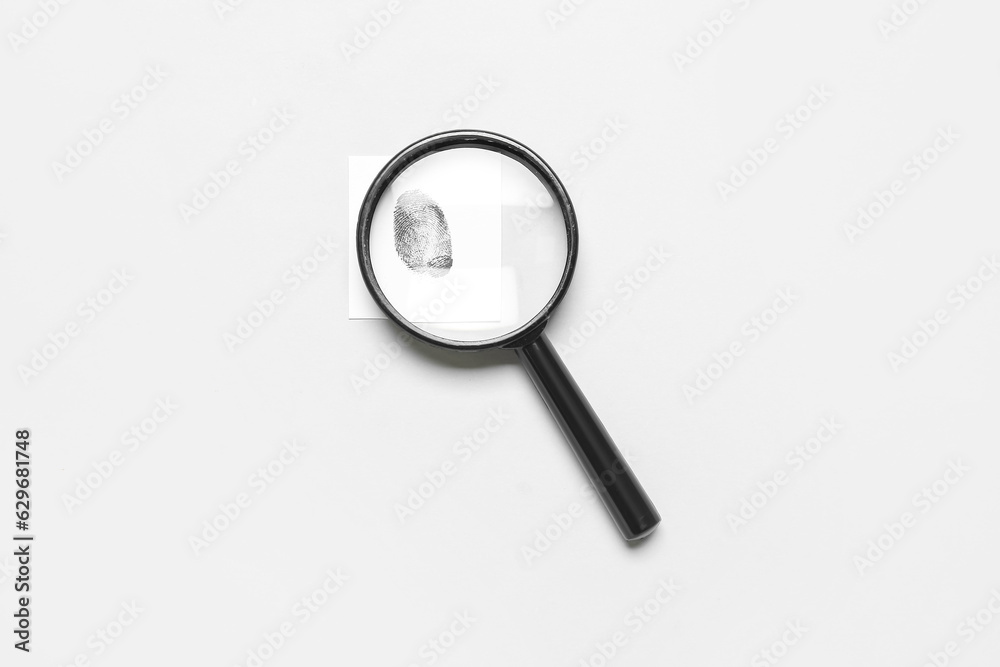 Magnifier and paper with fingerprint on grey background. Detective concept