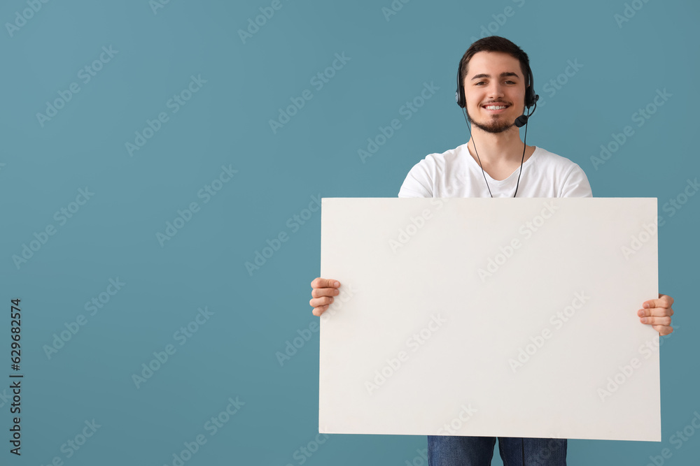 Male technical support agent with blank poster on blue background