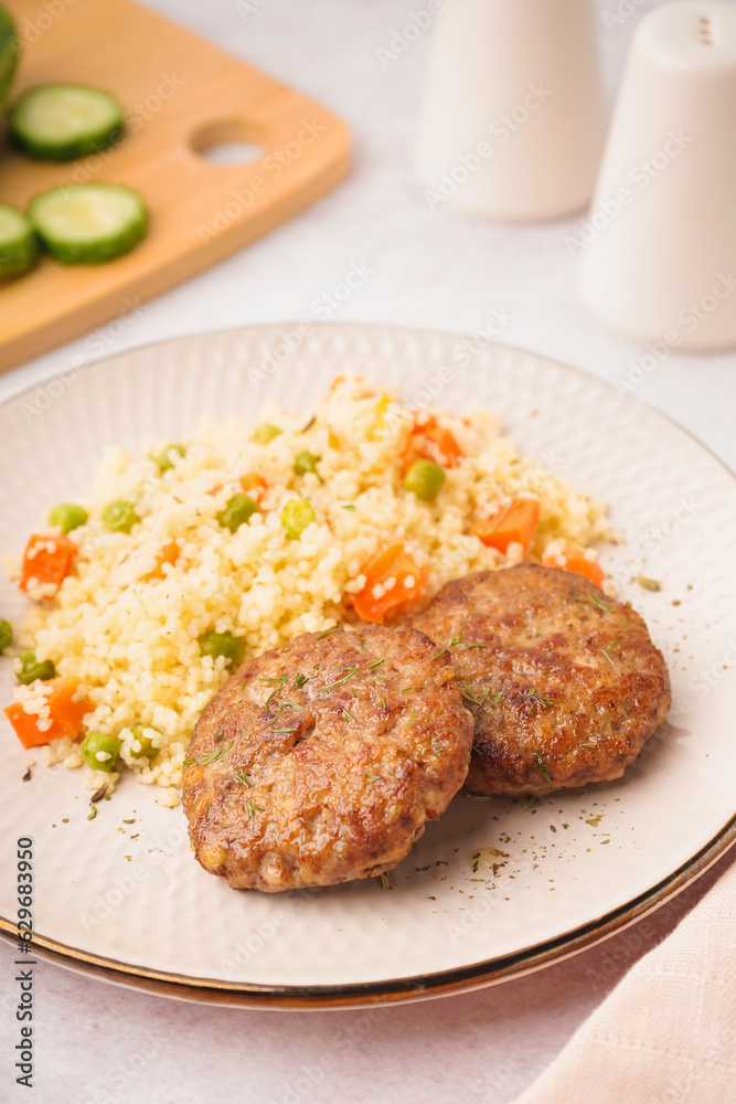 Cutlets with bulgur and boiled vegetables on light table in kitchen