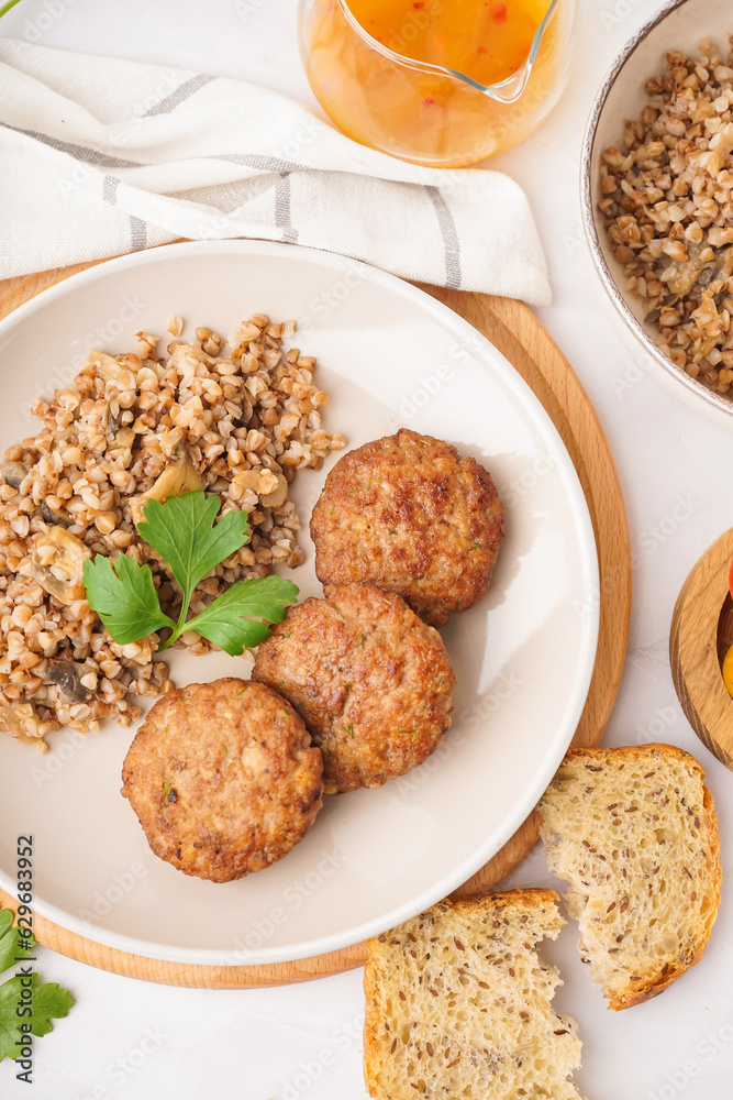 Cutlets with buckwheat, mushrooms and parsley on white table in kitchen