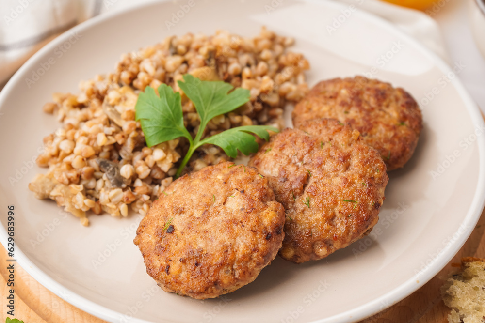 Cutlets with buckwheat, mushrooms and parsley on white table in kitchen