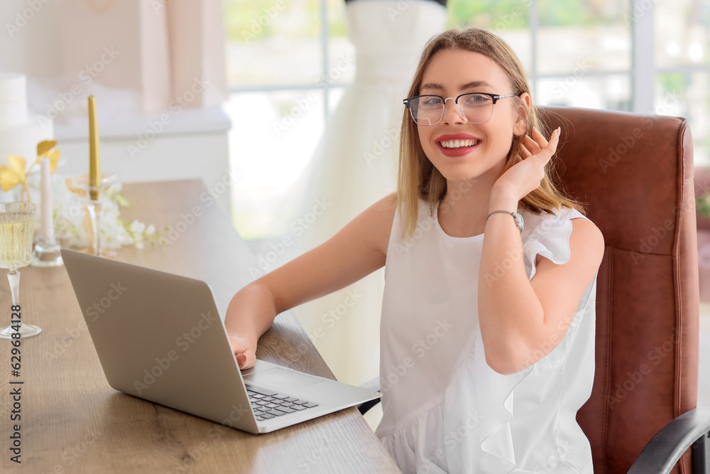 Female wedding planner working with laptop in office