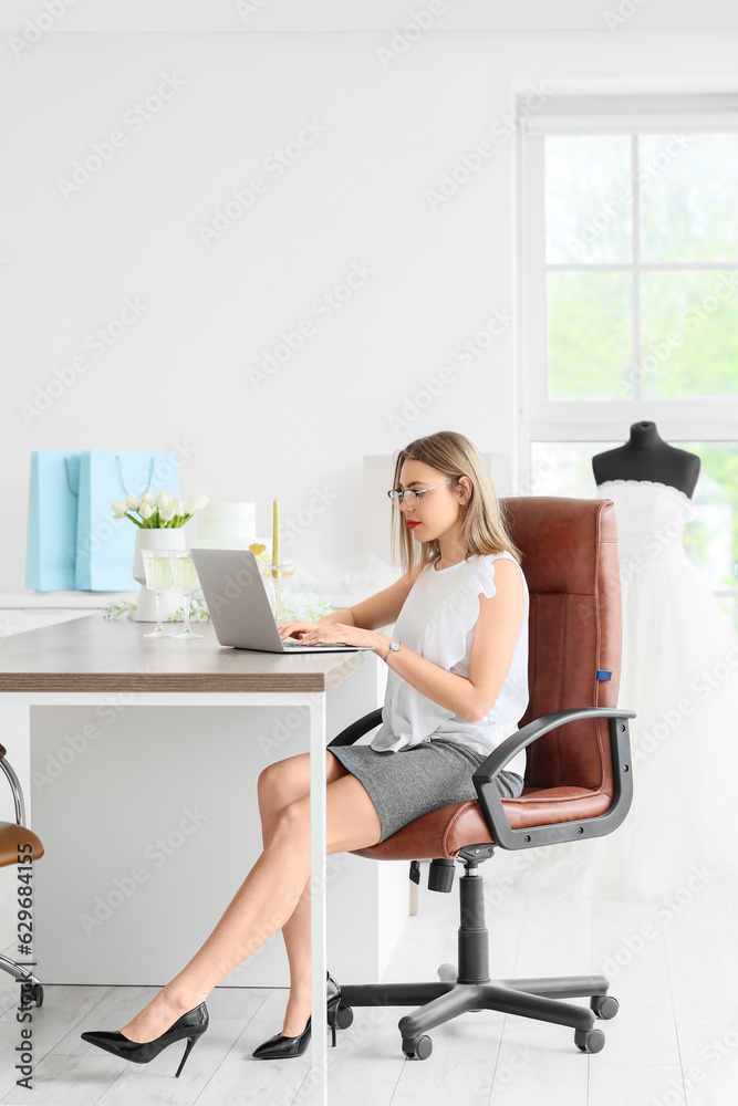 Female wedding planner working with laptop in office