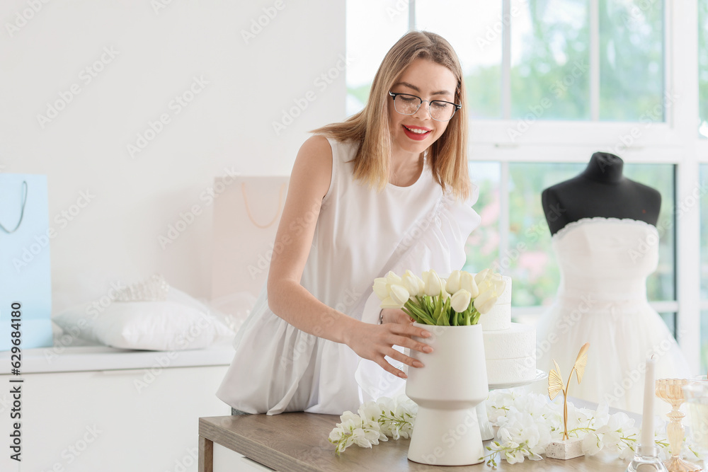 Female wedding planner working with flowers in office