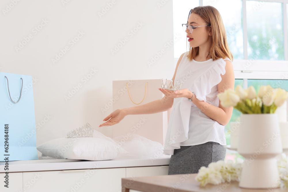 Female wedding planner with crown in office