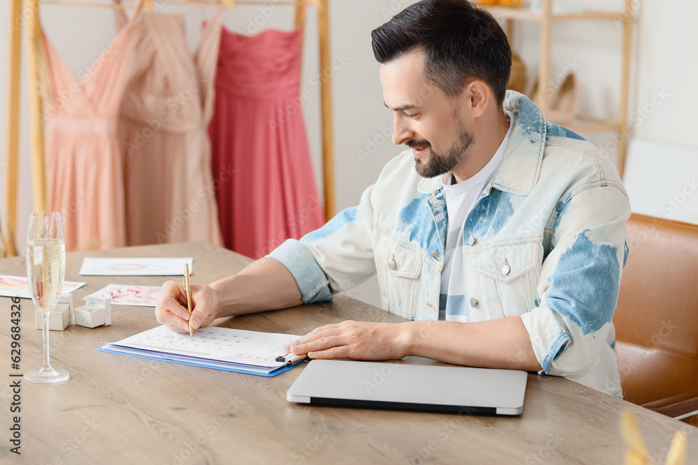 Male wedding planner working in office