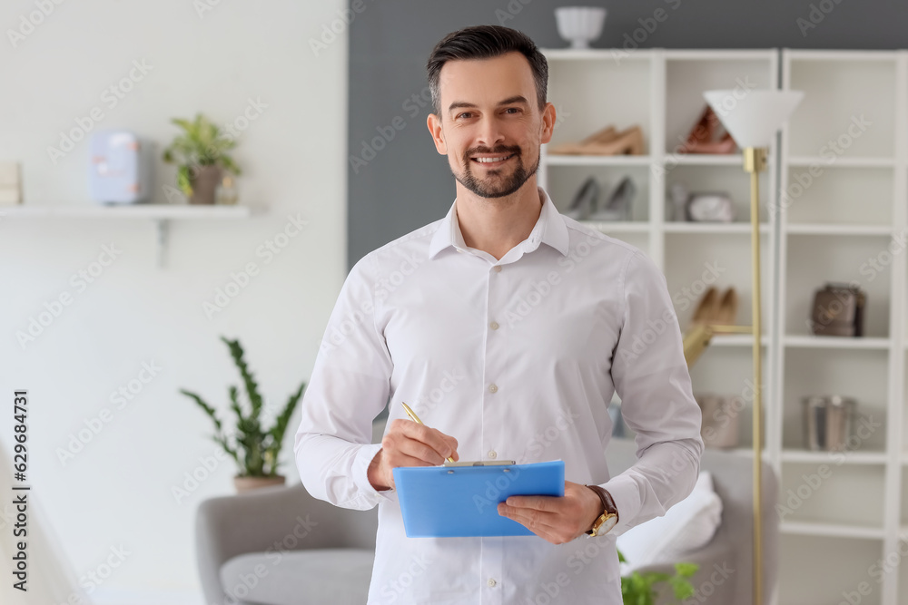 Male wedding planner with clipboard working in office