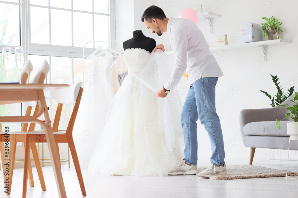 Male wedding planner with dress working in office