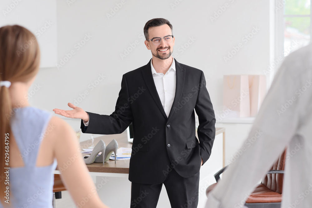 Male wedding planner working with couple in office