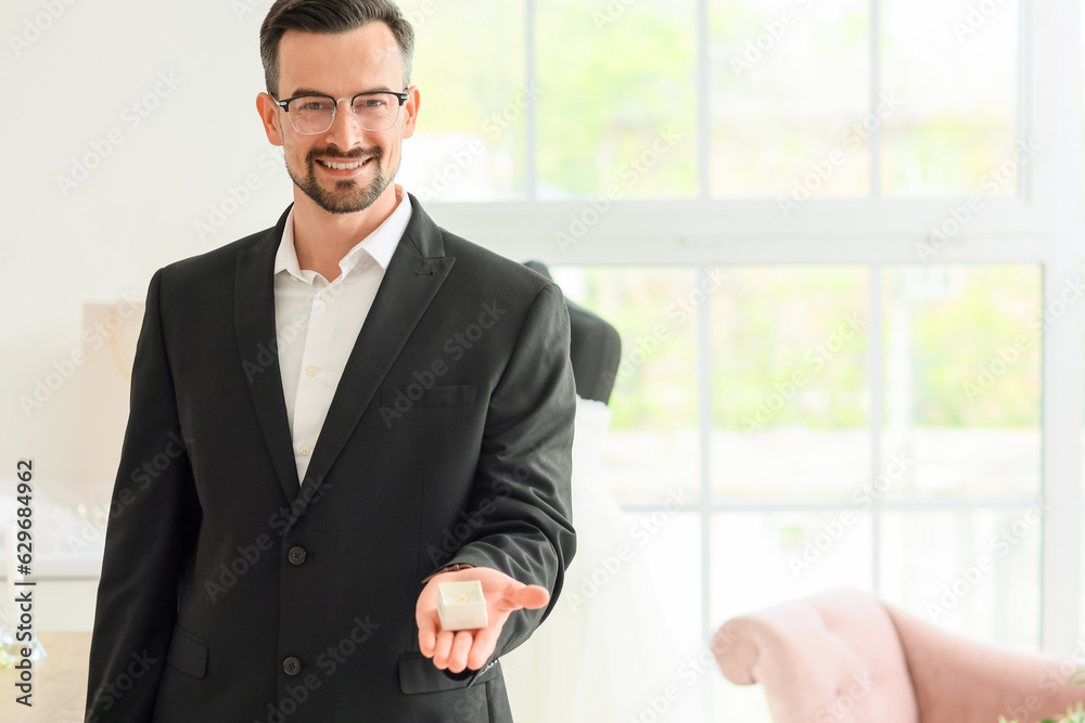 Male wedding planner with ring in office