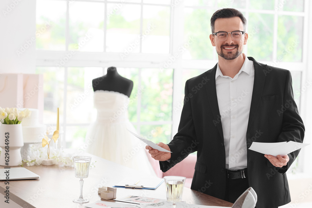 Male wedding planner working with pictures in office