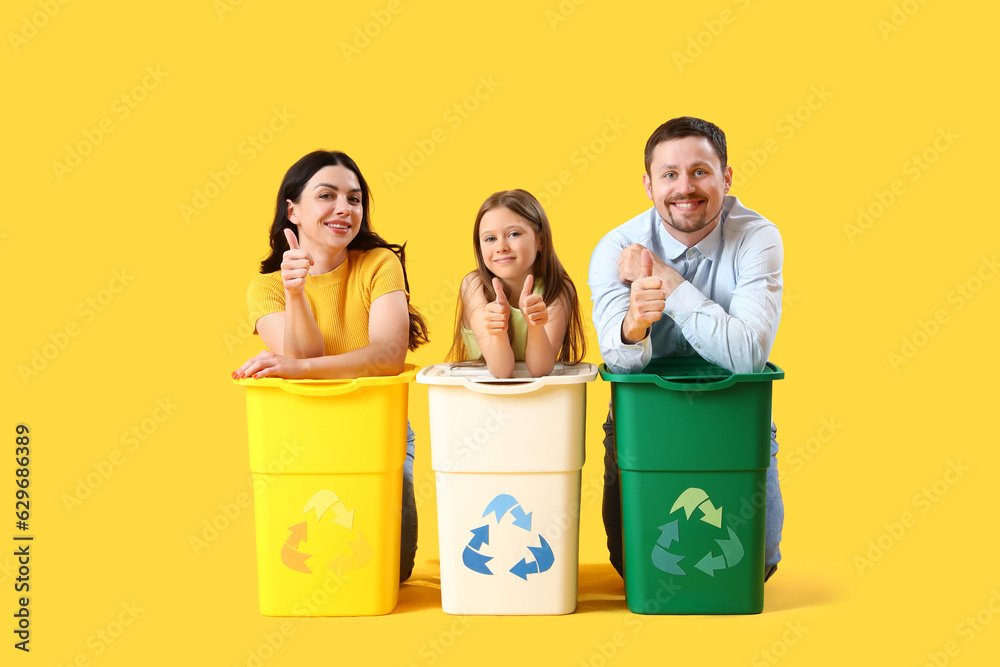 Family with recycle bins on yellow background