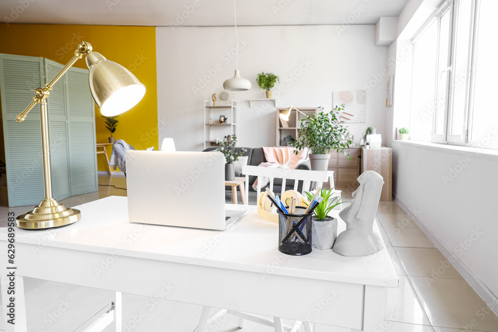 Interior of living room with workplace and glowing lamps