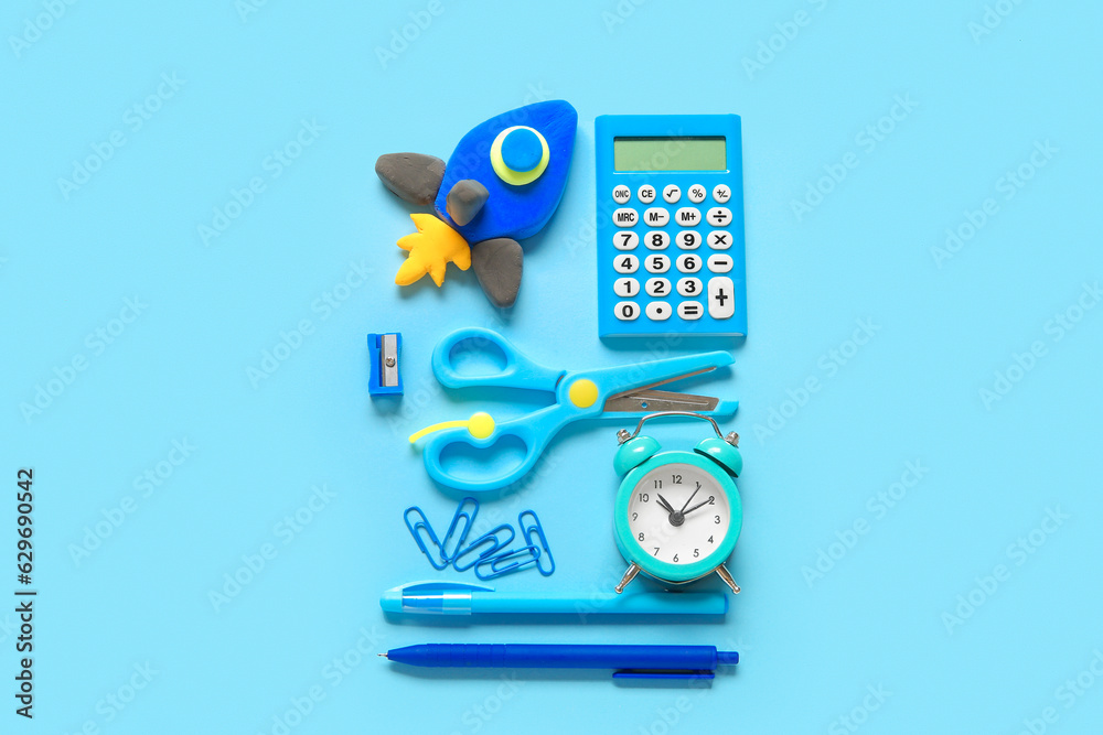 Rocket made of plasticine with different stationery on blue background