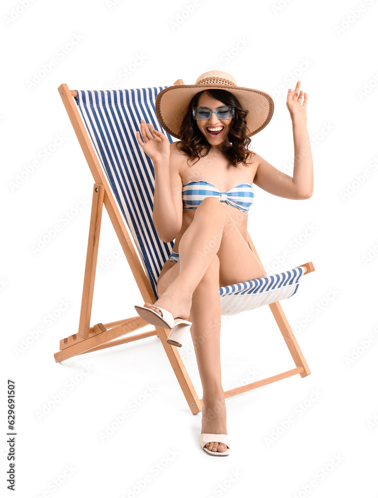 Young woman in deck chair on white background