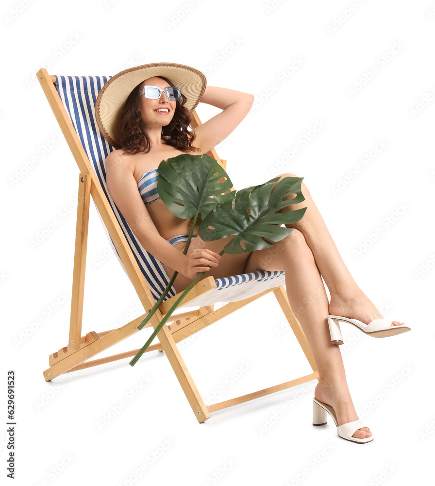 Young woman with palm leaves in deck chair on white background