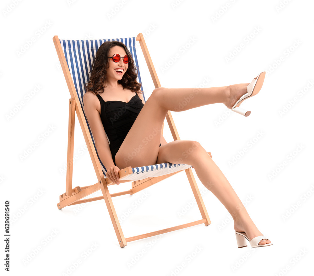 Young woman in deck chair on white background