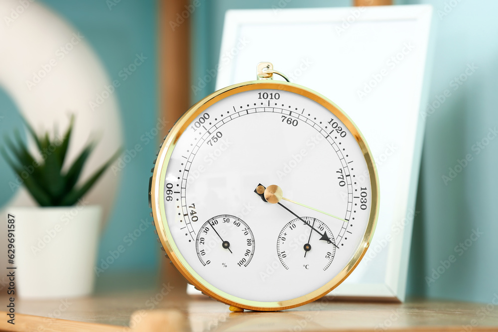 Aneroid barometer on wooden table in room, closeup