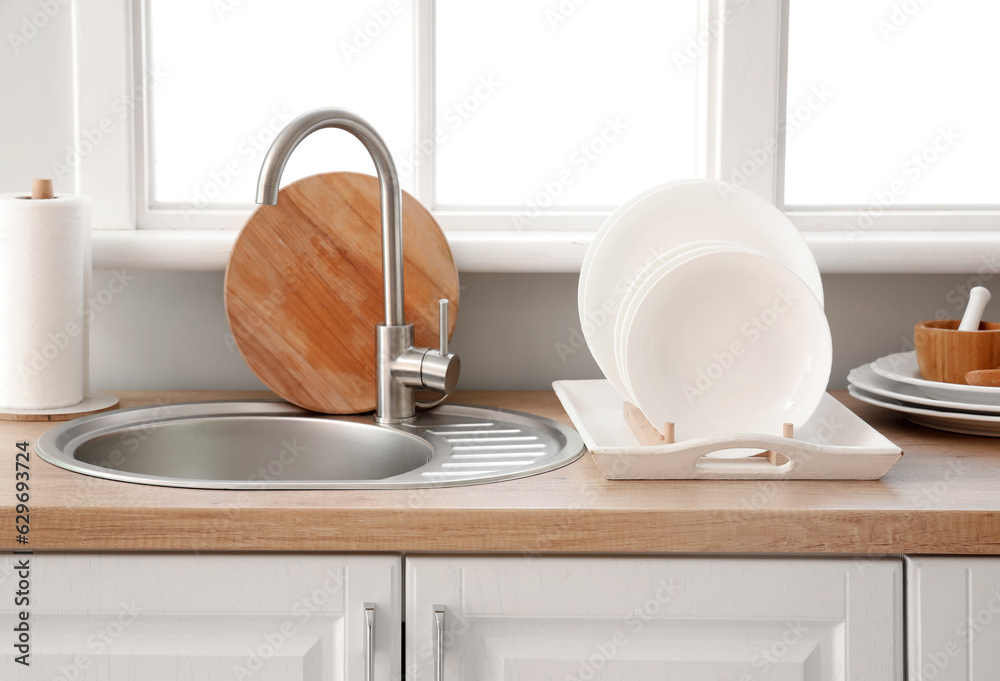 Kitchen counter with sink and plate rack near window