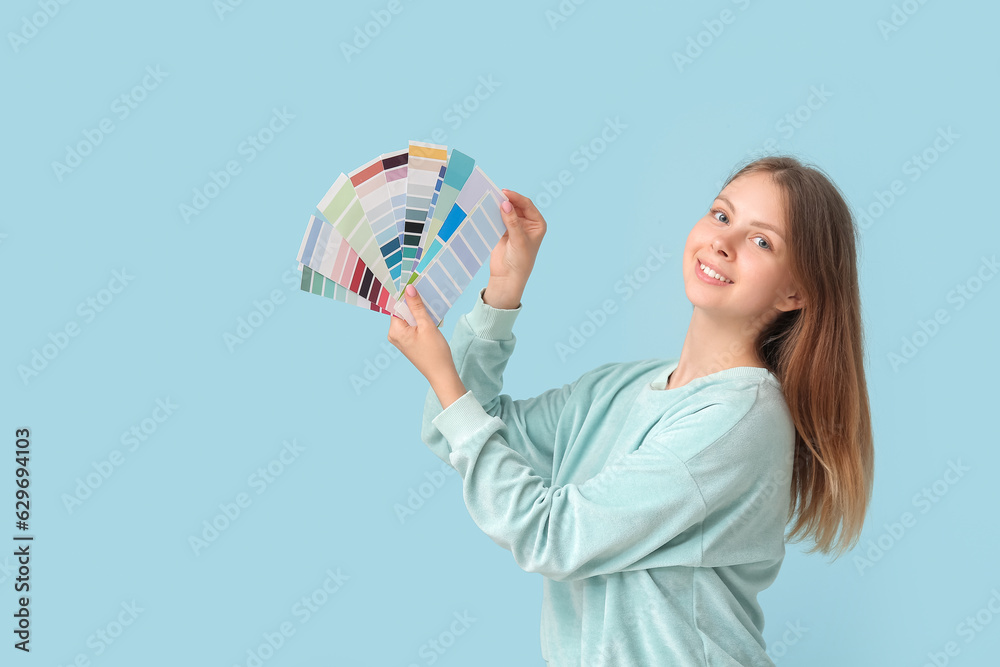 Young woman with color palettes on light blue background