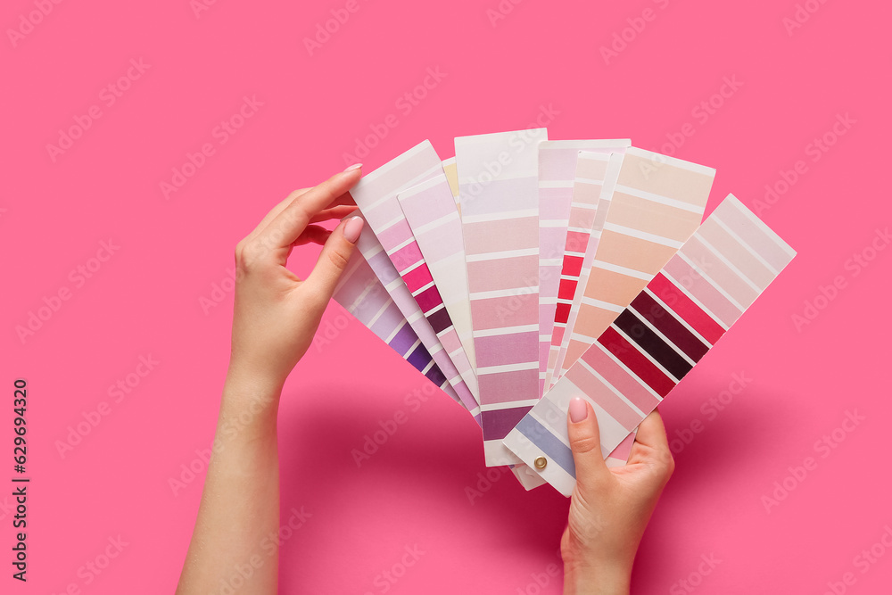 Hands with color palettes on pink background