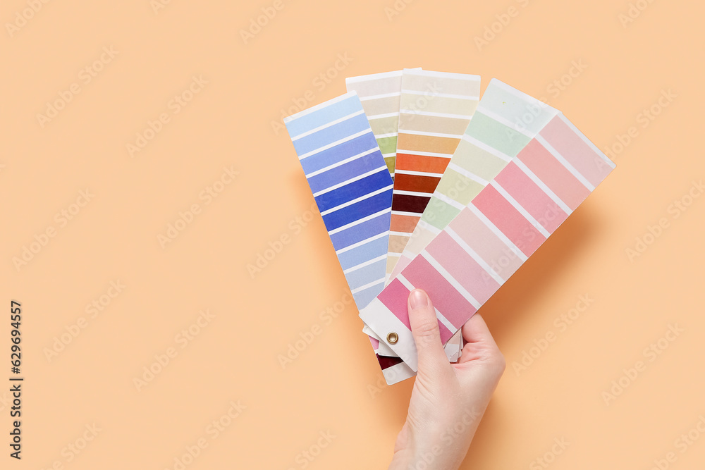 Hand with color palettes on beige background