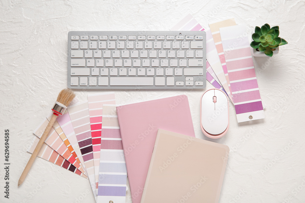 Color palettes, PC keyboard, notebooks and brush on light background, top view