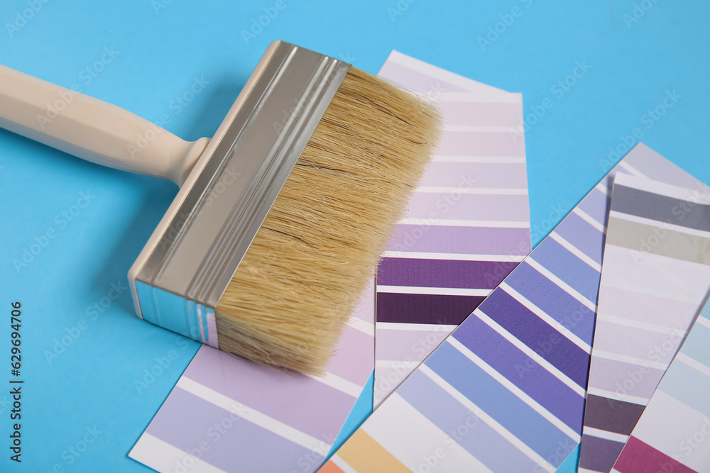 Many color palettes and brush on blue background, closeup