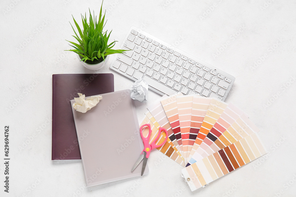 Color palettes, PC keyboard, notebooks and scissors on light background