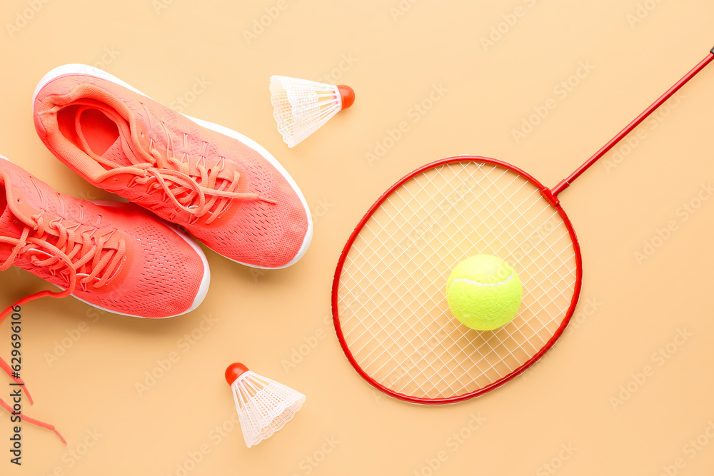 Stylish sneakers, tennis racket, ball and shuttlecocks on color background