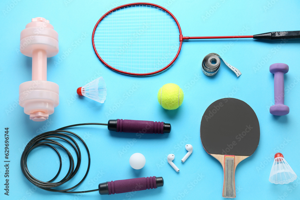 Composition with different sports equipment with earphones on color background